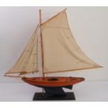 A bespoke wooden pond yacht upon a plinth stand (full length (sail to sail) 97cm, full height (