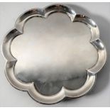 A heavy hallmarked silver salver of flowerhead shape and raised on four bun-style feet' maker's mark