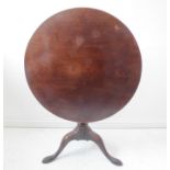 A good 18th century circular one-piece tilt-top occasional table - gun-barrel-style turned stem on