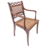 A Regency period mahogany and rattan caned open armchair; pierced lozenge-shaped top rail above