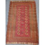 A 20th century Afghan Turkeman rug; central red ground, rectangle containing two vertical rows of