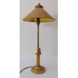 A 19th century style (later) brass table lamp; fan-shaped conical brass shade above a turned stem