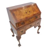 An early 20th century walnut and figured walnut writing bureau in early 18th century style; the