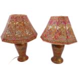 A pair of baluster-shaped Indian wooden table lamps with elaborate shades; the lamps very ornately