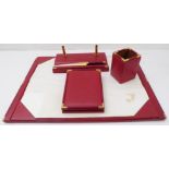 A large red-leather desk set by Asprey: large blotter, pen-holder and gilded letter-opener with