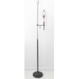 A free standing adjustable black painted iron lamp standard on circular base (189cm full height)