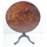 A George III period circular figured mahogany one-piece-top occasional table; turned stem leading to