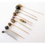 A small collection of nine stick pins including an old brilliant-cut example within a textured