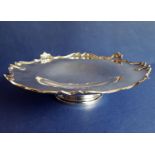 A hallmarked silver pedestal dish with raised decorative border in relief, on circular spreading