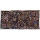 A finely stitched Indian wall hanging of multicoloured patchwork design and with small circular
