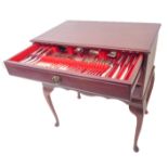 A three-drawer mahogany cutlery/flatware chest raised on cabriole legs. The 12-place silver-plated