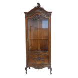 A Louis-XV-style (20th century) carved walnut and glass-sided vitrine of tall slim proportions: