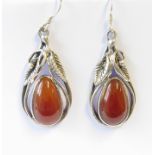 A pair of silver drop-earrings of pear form, each set with a polished red hardstone en cabochon (