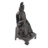 A patinated Chinese bronze of a high ranking official with headdress and long flowing robe, seated