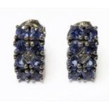 A pair of silver stud earrings, each set with eight tanzanites (boxed)