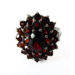 A 9-carat white gold garnet cluster ring of tiered, oval cluster design to the plain shank,