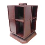 A large stained wood revolving bookcase on plinth base with canted corners (57cm square x 90cm