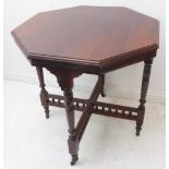 An Edwardian octagonal walnut occasional table raised on turned tapering legs, united by a cross