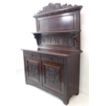 A late 19th century carved oak dresser: the pediment with a central incised scallop-shell motif