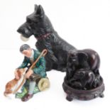 A large fireside pottery model of a Scottish Terrier holding a golf ball and a Royal Doulton figure,