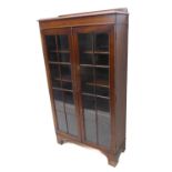 An early 20th century oak display cabinet / bookcase: the galleried top above two glazed doors