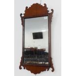 An 18th century style mahogany wall hanging looking glass (68cm highest) (37.5cm widest)