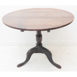 A George III period circular oak tilt top occasional table; turned stem and three downswept legs