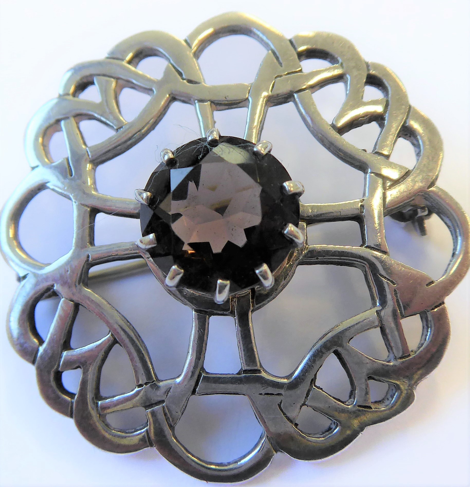 A hallmarked Scottish silver brooch in Celtic-style with a central hand-cut citrine within a