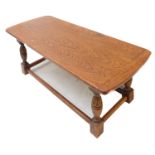 A reproduction oak occasional coffee table; the figured top with bowed, cleated ends above a chip-