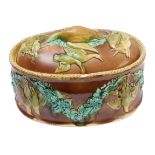 A 19th century oval majolica glazed game pie dish; the lid decorated in relief with game birds,