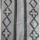 A pair of green and cream curtains edged with a broad band of green fabric, triple pinch pleat