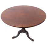 A George III period circular tilt top mahogany occasional table; the well figured single piece top