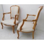 A pair of modern fauteuils in the mid-18th century Louis XV style: upholstered natural show-wood,