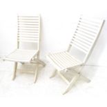 A pair of slatted white-painted folding garden seats