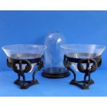 A pair of circular bowls within iron stands modelled as open-winged swans, together with a glass