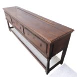 An 18th century oak dresser base; the large outset moulded top above three frieze drawers with