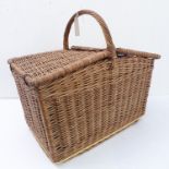 A wicker picnic basket with central carrying handle and two angular covers on leather hinges (55cm