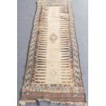 An unusual early 20th century hand-knotted Eastern runner; central beige and brown design of a