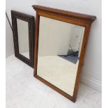 An early 20th century oak-framed wall-hanging looking glass, the frame carved with half flowerheads,
