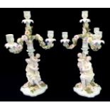 A pair of 19th century Dresden two-piece candelabra: removable four-arm candle holders over a female