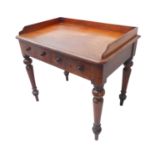 A good mid 19th century mahogany clerk's table; the three-quarter galleried top above two half-width
