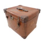 An early 20th century leather-mounted travelling trunk; hand-stitched leather handle above the