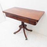 An early 19th century Regency period foldover top mahogany tea table; figured frieze, turned stem