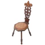 An early 20th century Welsh-style oak spinning chair; decorative vertical pierced back above a