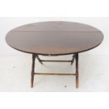 A late 19th / early 20th century circular coaching-style table: stained wood (pine legs and oak