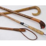 Three walking sticks and an early 20th century leather riding crop; one stick with its handle carved