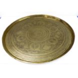 A large early 20th century circular Eastern brass serving tray; engraved with a central flowerhead