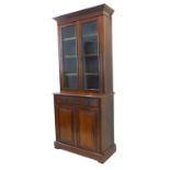 An Edwardian period walnut bookcase cabinet; outset cornice above two glazed doors enclosing