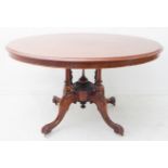 A mid 19th century oval mahogany tilt-top loo table; moulded edge top above four turned supports and