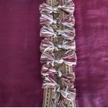 A pair of burgundy slub silk curtains edged with decorative tasselled braid, triple pinch pleat